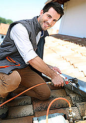 A professional roofer installs a new tile roof on a residential home using the best roofing installation techniques.