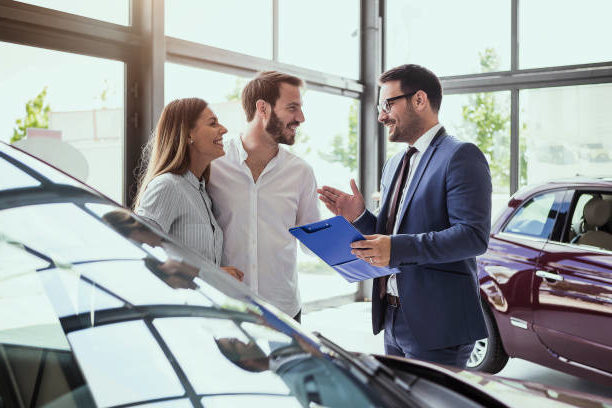 A couple buys a new car from a local auto dealer specializing in car sales of their preferred make and model.