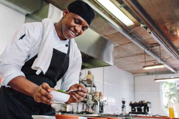 A catering chef prepares a gourmet dish before sending it out to his clients.