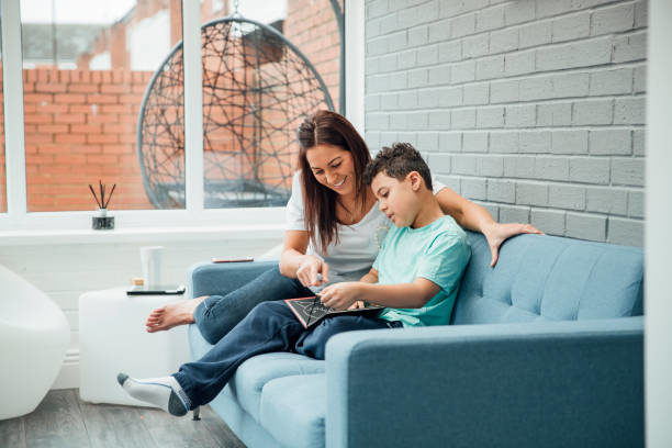 A mom helps her son with his homework in their sunroom, which features new glass installed by local glass repair contractors.