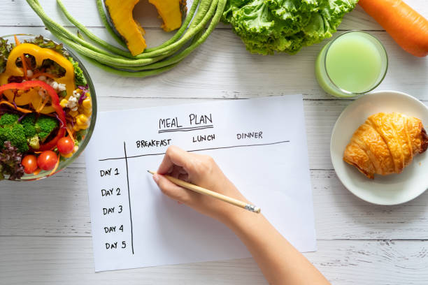 A weight loss program client works to fill out the meal plan she's developed at the local weight loss clinic she's attending.